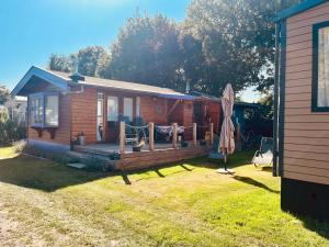 a small house with a deck and an umbrella at Chalet Lavendel in Schimmert
