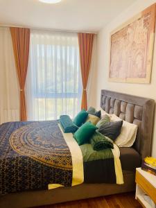 a bedroom with a bed with pillows and a window at Citysmart Apartment in Tuzla