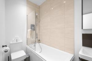a white bathroom with a tub and a toilet at Eastons 1 Bedroom Apartment with Sofa Bed in High Wycombe +13 photos
