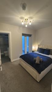 a bedroom with a large bed with a blue blanket at 7-Min Walk to Principality and City Centre in Cardiff