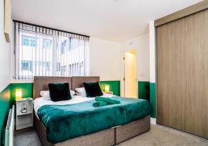 a bedroom with a large bed and a large window at Contemporary Two-Bedroom Apartment - Parking, Fast Wi-Fi, Great for Business & Relocation by AV Hughes Properties in Milton Keynes