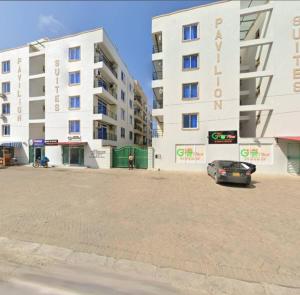 a car parked in a parking lot in front of a building at Luxurious Pavilion Nest in Mombasa