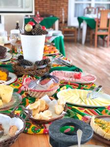 a table topped with plates of food and snacks at Pousada Filosófica in Campos do Jordão
