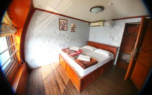 a small bedroom with a bed in a boat at Alleppey Lake Houseboat in Alleppey