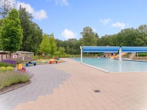 a swimming pool with a pavilion in a park at chalet in the woods with pool in Vledder