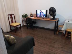 a desk with a computer on it in a living room at Apt, espaço inteiro no 1° andar. in Canoas