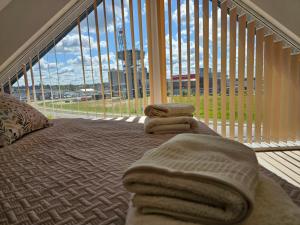 a balcony with towels on a bed in front of a large window at Apartament KONGRESOWA VIEW in Kielce