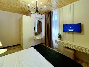 a hotel room with a bed and a tv at SOLAR Hotel and Restaurant in Gabala