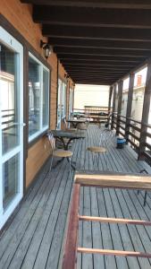 una terraza de madera con mesas y sillas en un edificio en Family, en Chornomorsk