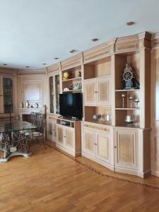 Una cocina grande con gabinetes de madera y una mesa. en fully-equipped luxury penthouse, en Almácera
