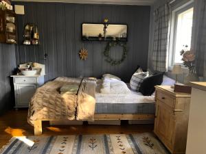 a bedroom with a bed and a mirror on the wall at Veslekoia - Grandmas Cabin in Øksna