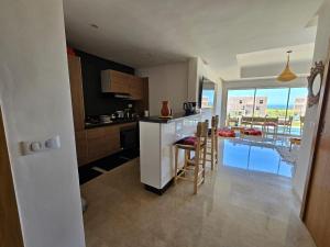 Authentic Taghazout في تغازوت: مطبخ مع كونتر وطاولة مع كراسي