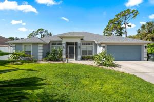 a house with a green lawn in front of it at 4 BR Heated Private Pool & Lanai in North Port