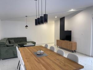 a living room with a wooden table and a couch at Casa La Familia in Posušje