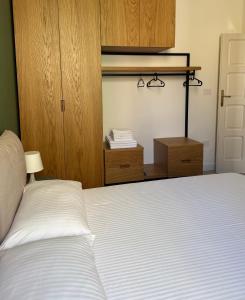 a bedroom with a white bed and wooden cabinets at Apulian Green Leaves House in Giovinazzo