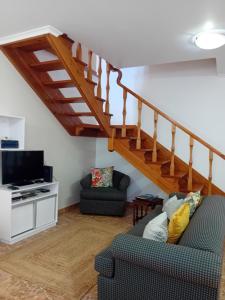 a living room with a staircase and a couch at Ribeirinha House in Porto Formoso