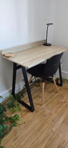 a wooden table with a black chair under it at Chambre d'hôtes avec petit déjeuner in Clermont-Ferrand
