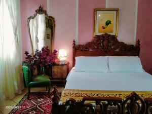a bedroom with a bed and a chair and a mirror at B&B Gardasee in Castelnuovo del Garda