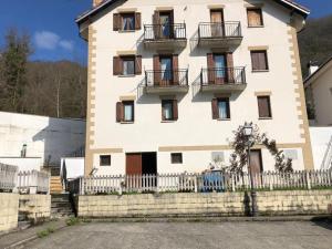 a large white building with balconies and a fence at Retaetxe in Orbaiceta