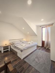 a white bedroom with a bed and a window at Apartmány Alexander in Vrbov