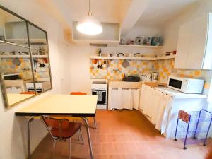 a kitchen with a table and chairs in a room at La Cachette centre historique village in Roussillon