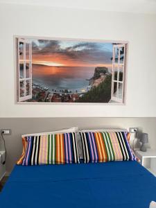 a bedroom with a blue bed and a window at Leonardo Suites Scilla in Scilla