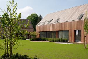 卡斯特尔莱Logies De Hoeven的一座前面有绿色草坪的建筑