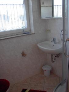 ein Bad mit einem Waschbecken und einem WC in der Unterkunft MaRa-Ferienhaus in Dranske