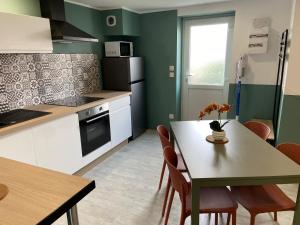 a kitchen with a table and a table and chairs at Joli appartement au calme in Bruay-la-Buissiere +18 photos