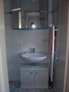 eine Person, die ein Bild von einem Waschbecken in einem Bad macht in der Unterkunft MaRa-Ferienhaus in Dranske