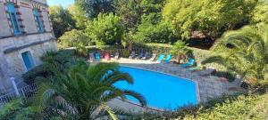 una piscina con tumbonas y sillas junto a un edificio en Résidence de Tourisme Vacances Bleues Villa Regina, en Arcachon