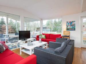 a living room with red couches and a tv at 6 person holiday home in Gørlev in Gørlev