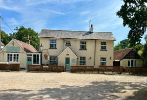 a large white house with two fences in front of it at The Pigs' Pantry, Burley in Burley