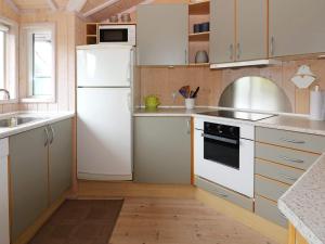 a kitchen with white appliances and a white refrigerator at 4 star holiday home in Hadsund in Hadsund