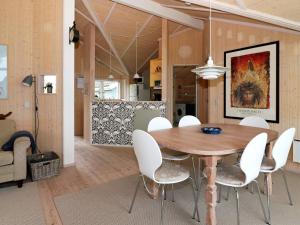 a dining room with a wooden table and white chairs at 6 person holiday home in Hadsund-By Traum in Hadsund +36 photos