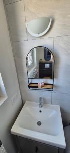 a bathroom with a white sink and a mirror at Chez T-E-O in Cognac
