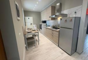 a kitchen with a stainless steel refrigerator and a table at Matteo Luxury Residence in Lomazzo
