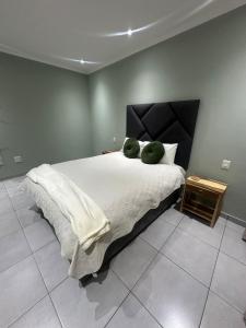 温特和克Little Haven Conerstone cottage的一间卧室，有一张大床，床上有两个绿色枕头 更多13张照片