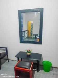 a mirror on a wall with a table and a mirror at Rithu Homestay in Sigiriya
