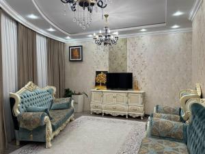 a living room with two chairs and a television at Promenade EXPO in Astana