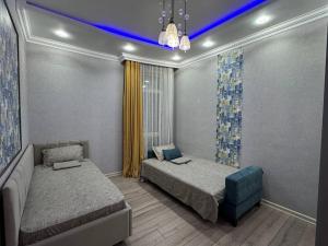 a bedroom with two beds and a blue ceiling at Promenade EXPO in Astana
