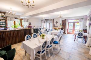 a dining room with white tables and blue chairs at Domki modułowe przy plaży in Sokole-Kuźnica +5 photos