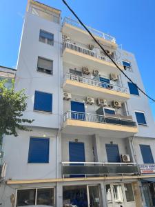 a white building with blue windows and balconies at Kountouriotou 24 hospitality in Chios
