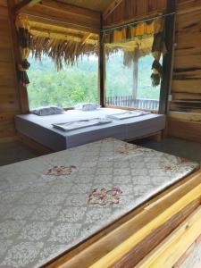 two beds in a room with a window at Nature Homestay Mù Cang Chải in Mù Cang Chải