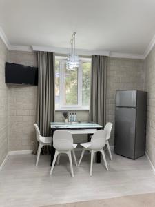 a kitchen with a table and chairs and a refrigerator at Apartament Privat Botanica in Chişinău