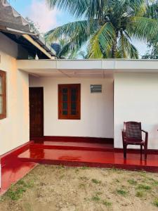einen Stuhl auf der Vorderseite eines Hauses in der Unterkunft Una Star Guest House in Trincomalee