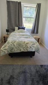a bedroom with a bed and a window at Te Anga Farmstay in Te Kuiti