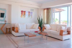 a living room with two white couches and a table at Rethymnian Luxury Seaview Apartment in Rethymno Town