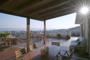 a patio with tables and chairs on a balcony at Rethymnian Luxury Seaview Apartment in Rethymno Town