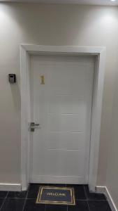 a white door with a sign in front of it at نايس لوكيشن in Taif
